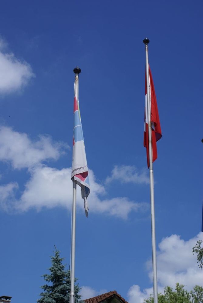 Zwei Standard Fahnenmasten mit Fahnen vor blauem Himmel